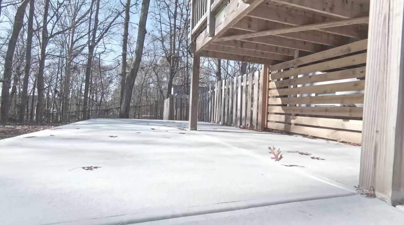 New concrete patio and pool deck slab poured under a raised deck structure in Abilene, TX